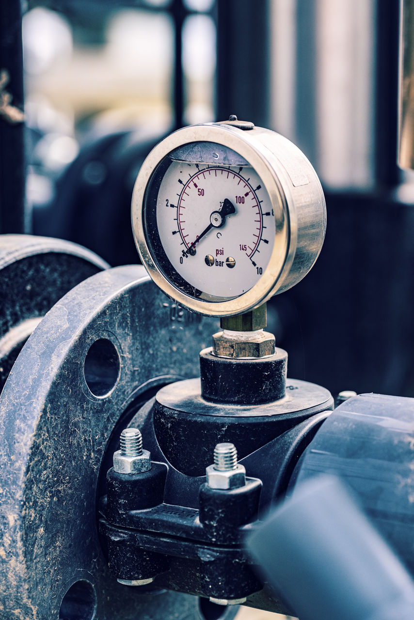 Industrial pressure gauge on metal pipeline system.