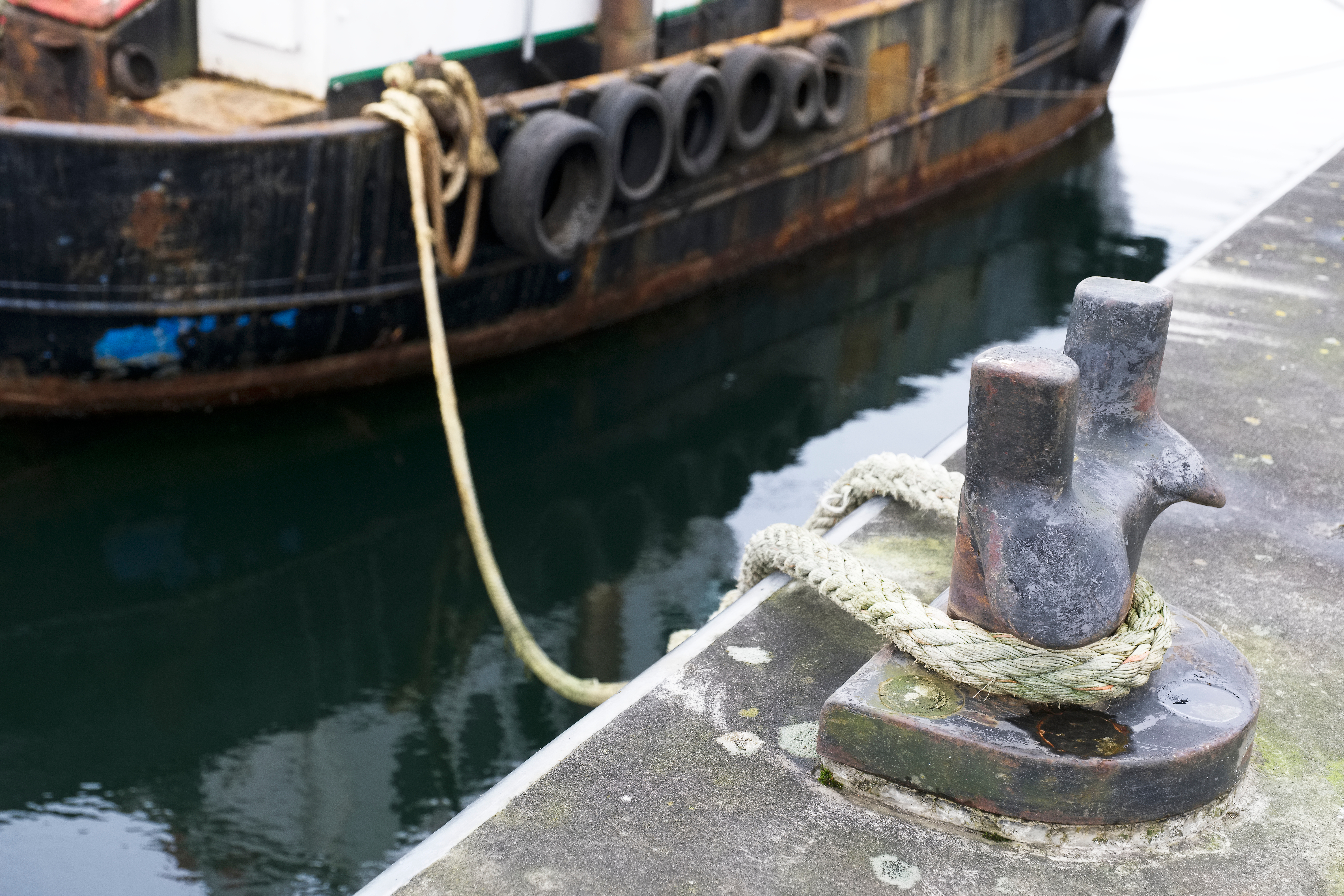Mooring bollard with rope securing docked boat