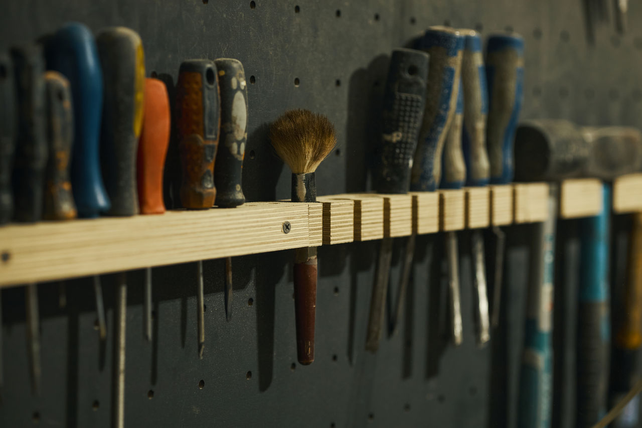 Assorted hand tools organized on workshop wall rack