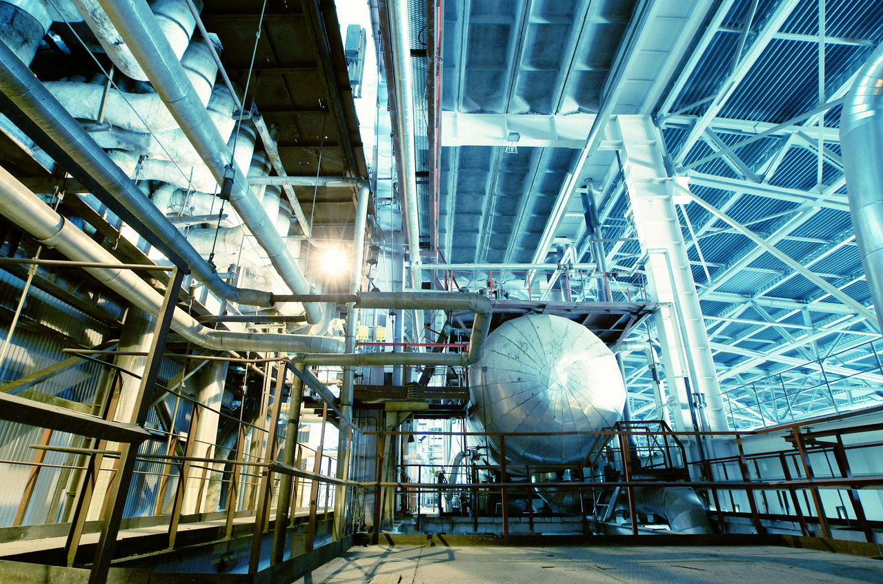 Industrial facility interior with large metal tanks and pipes
