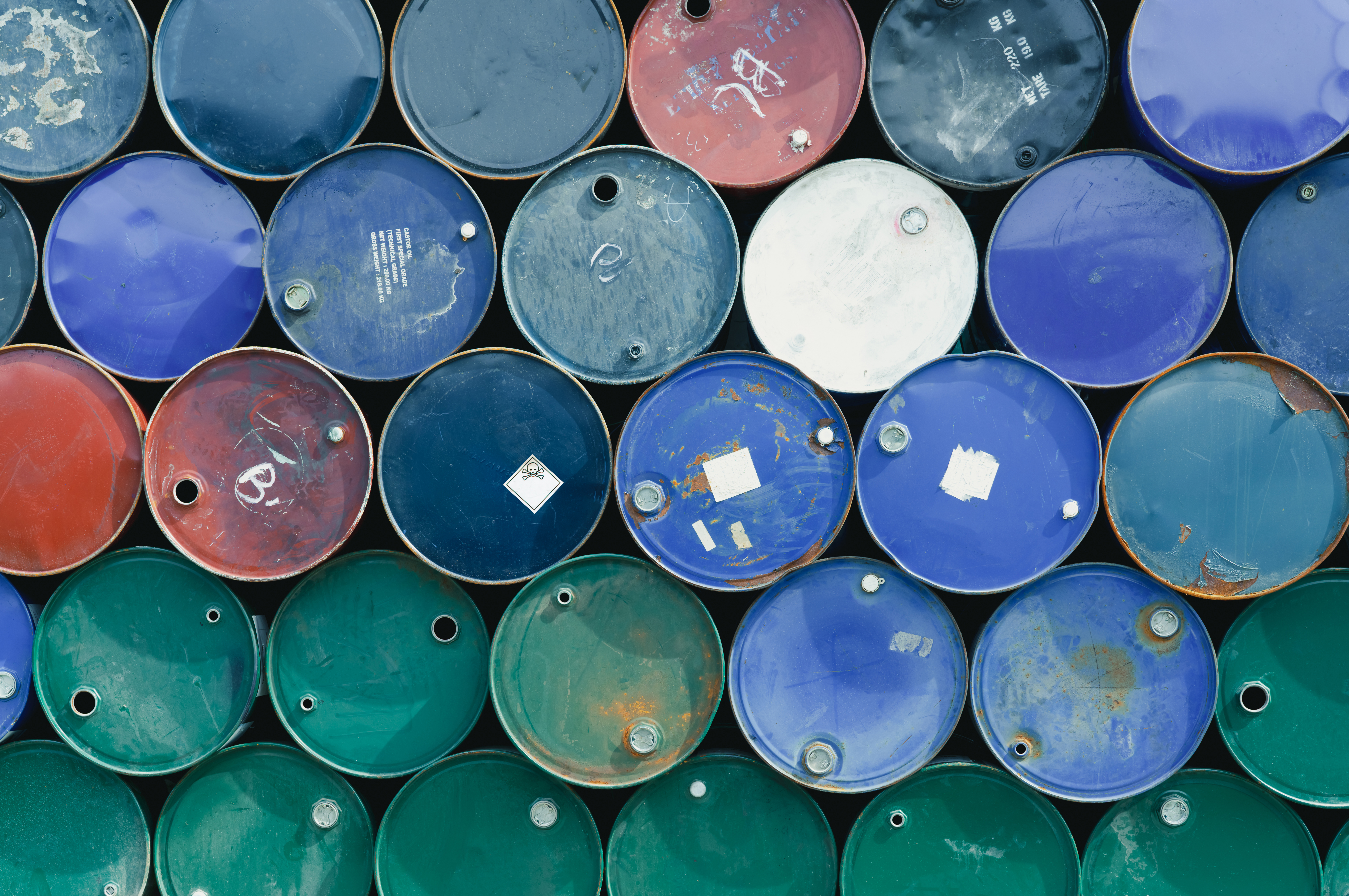 Stacked colorful industrial barrels in outdoor storage