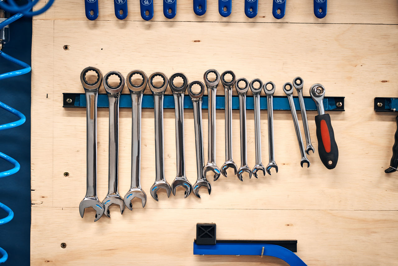 Organized set of wrenches and ratchet on workshop wall