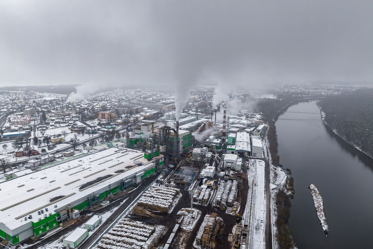 Aerial view of industrial plant by snowy riverbank